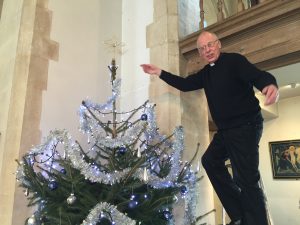 Inside church Fr Roger with Christmas Tree